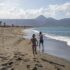 Two happy children run on the sandy shore