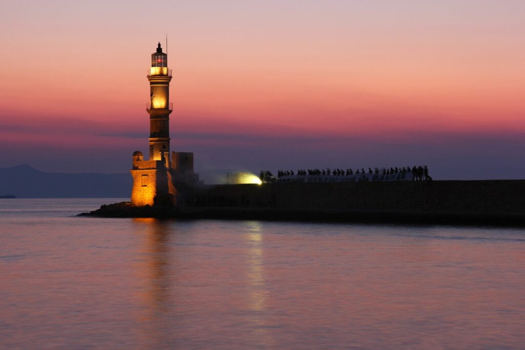 A lit-up lighthouse at sunset