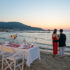 Couple standing next to a romantic table at the beach