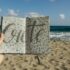 Hand holding a notebook at the beach writing Crete