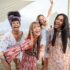 Smiling multiracial girls dancing at sunset beach party - four young girls having fun at bar